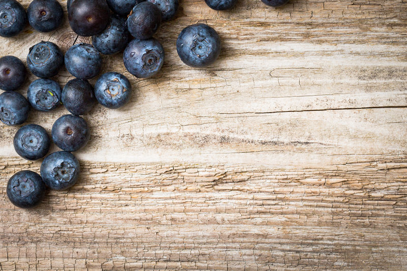 木制背景上的蓝莓
