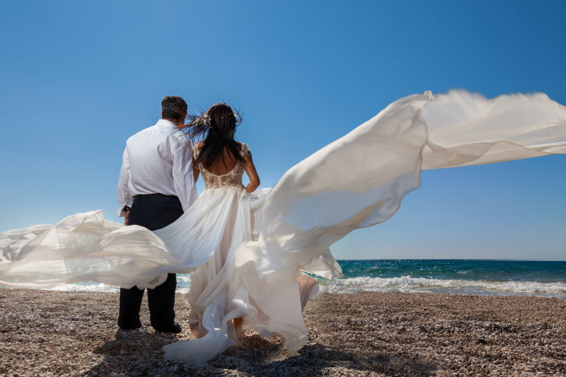 一对新婚夫妇站在热带海滩上