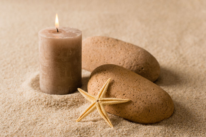 沙滩上的棕色蜡烛和石头