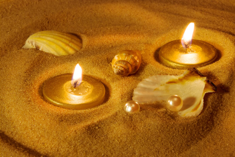 沙滩上的蜡烛和珍珠贝壳