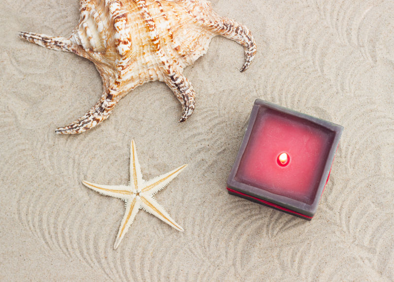 沙滩上的贝壳和点燃的蜡烛