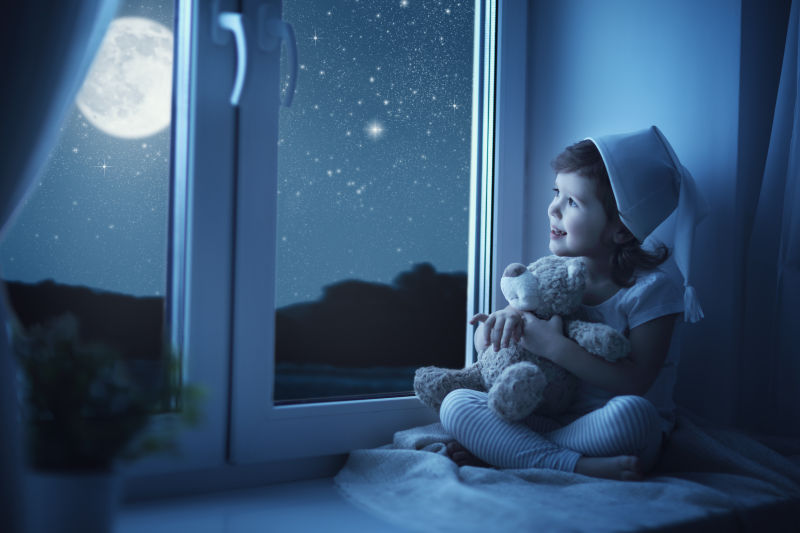 坐在窗户口看月亮的小女孩