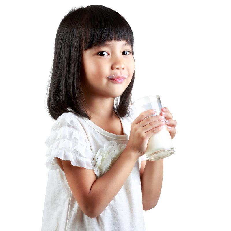白色背景下快乐的小女孩捧着一杯牛奶