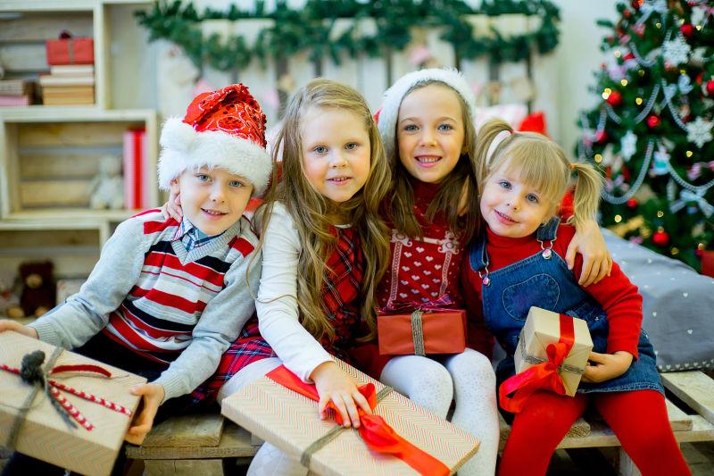 可爱的四个小女孩拿着圣诞礼物