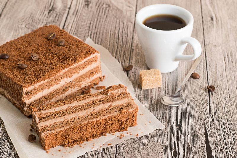 木制背景在羊皮纸上的巧克力蛋糕和咖啡