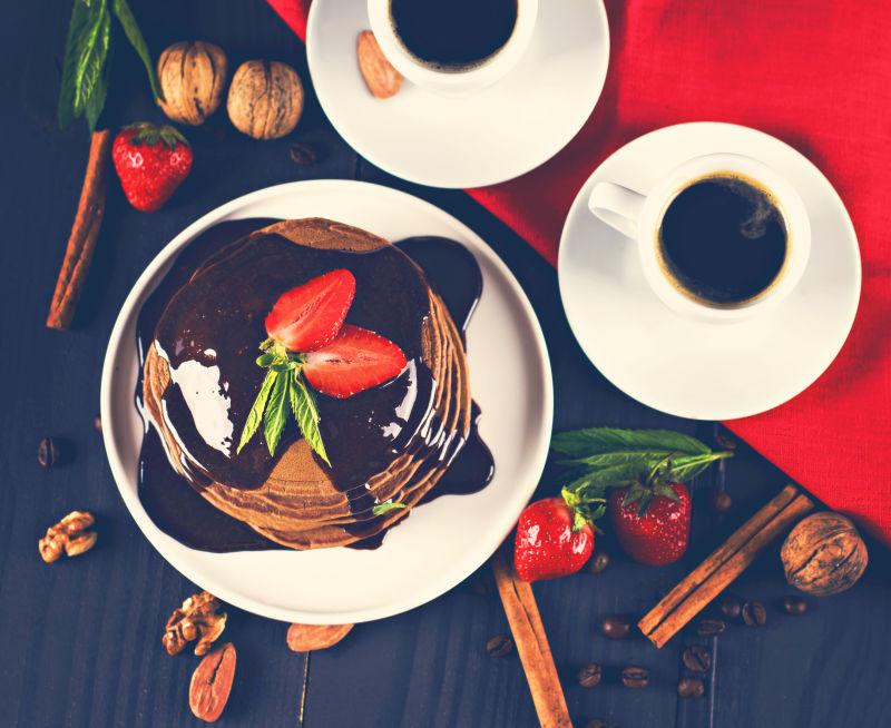 巧克力薄饼配巧克力酱和草莓在木桌上