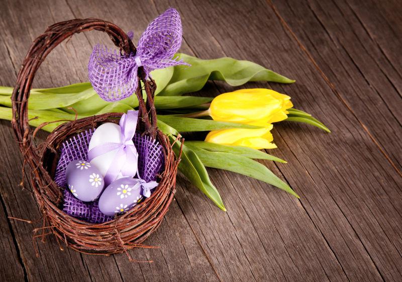 木板上竹篮中的紫色复活节彩蛋
