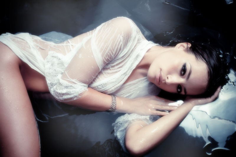 穿着白色湿衬衫躺在水中的性感美女