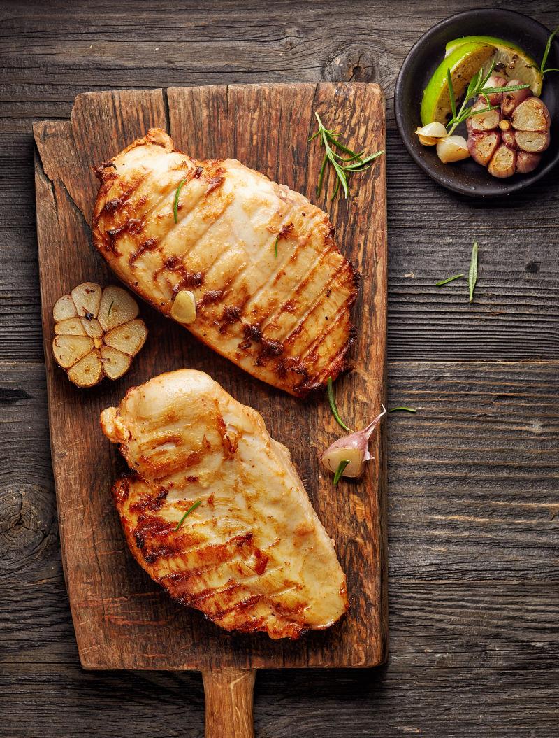 木制菜板上的烤鸡胸肉