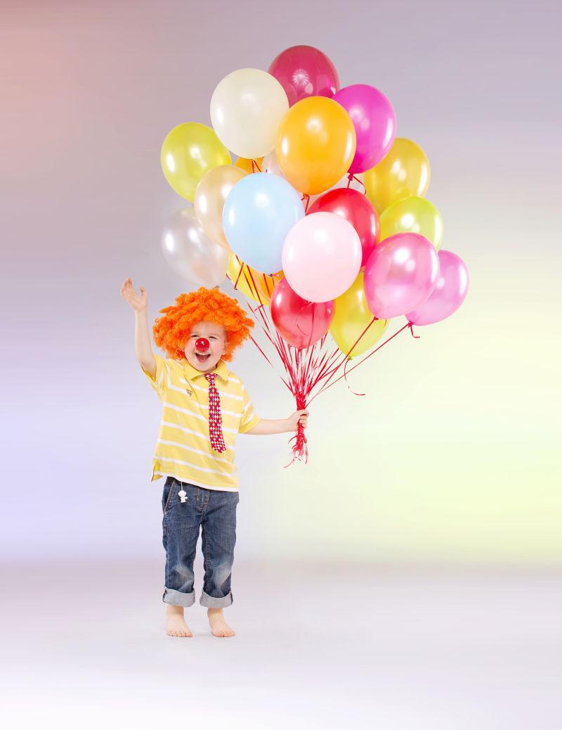 抱着一捆气球的小孩