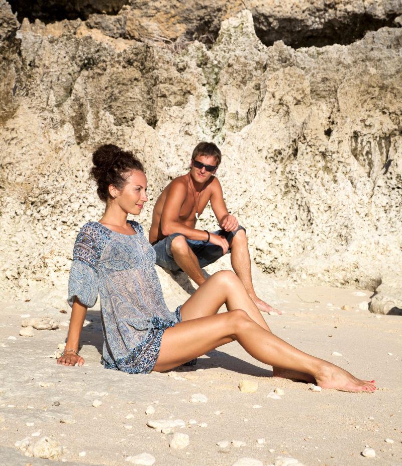坐在海滩上的幸福的年轻夫妇