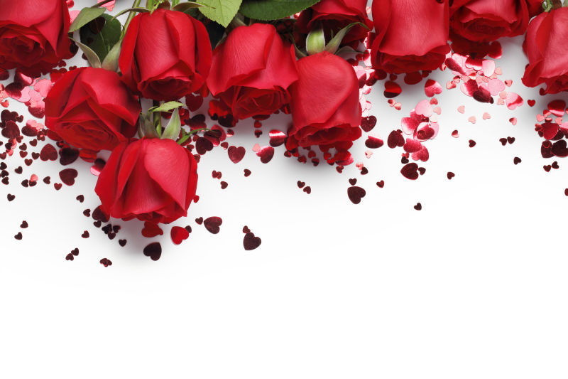 白色背景上的红玫瑰和心形饰物