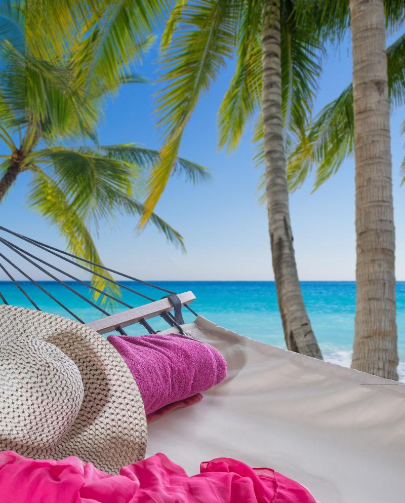 热带海滩棕榈树下的空吊床