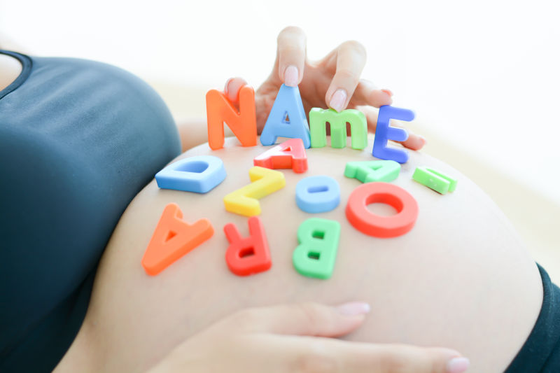 怀孕的母亲在肚子上放着英文字母
