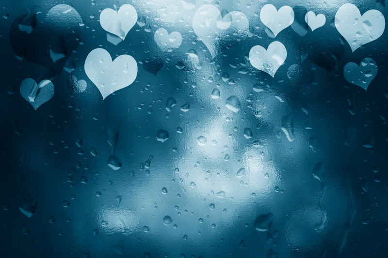 情人节蓝色玻璃上的心形和水珠