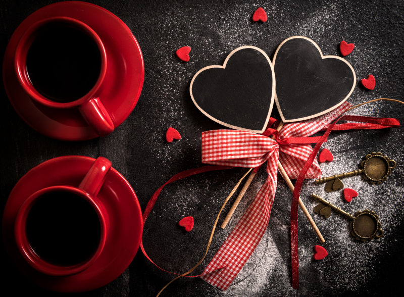 情人节桌上的红色杯子和心形礼物装饰