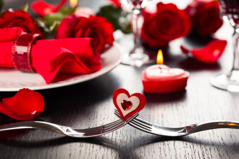 情人节餐厅的场所玫瑰和叉子蜡烛设置背景
