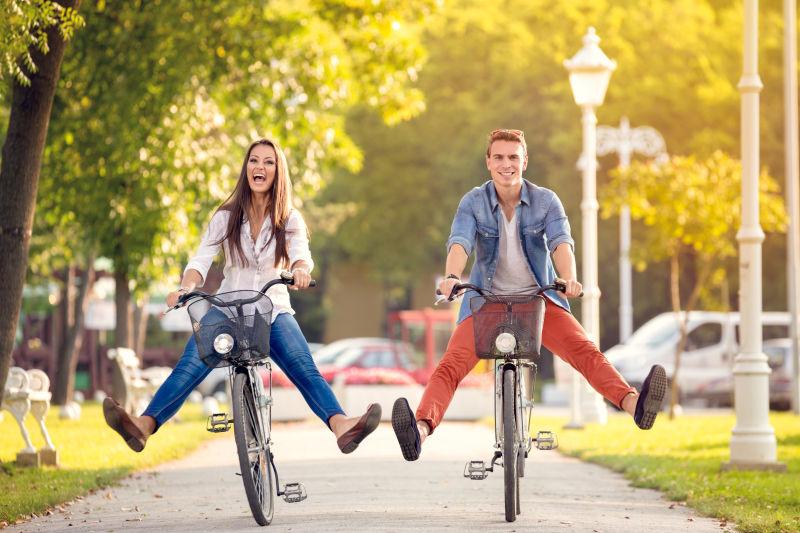 快乐滑稽的年轻夫妇骑自行车