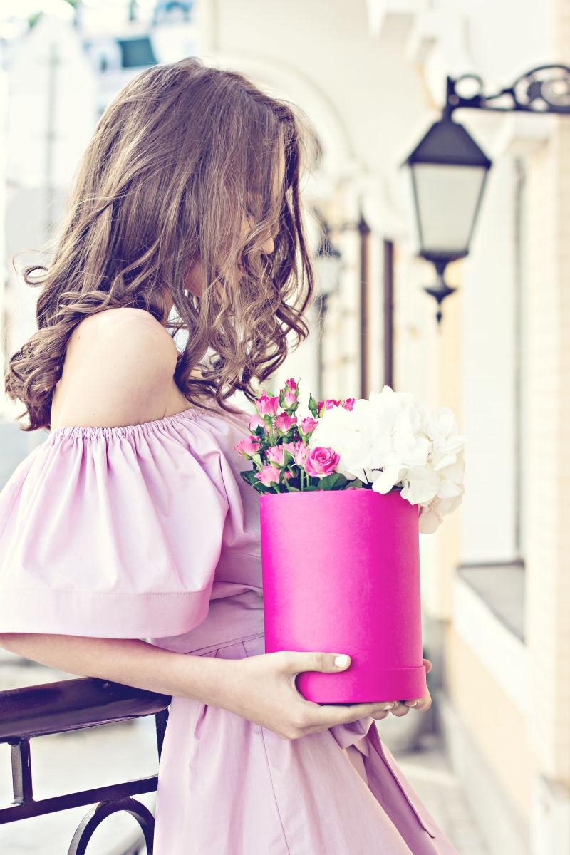 美丽的女人抱着一盒新鲜的花束
