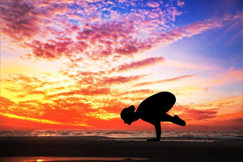 日落天空背景下练习瑜伽的女子