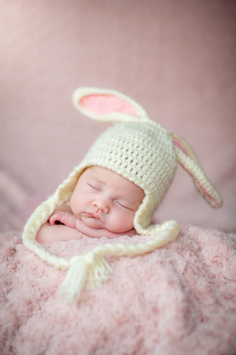 戴着白色兔子耳朵帽睡觉的宝宝