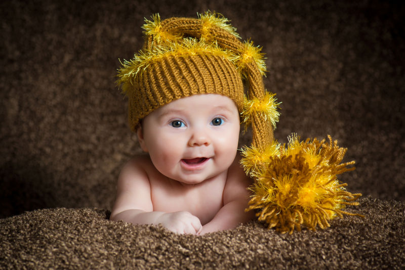 新生儿的针织冬帽米色背景