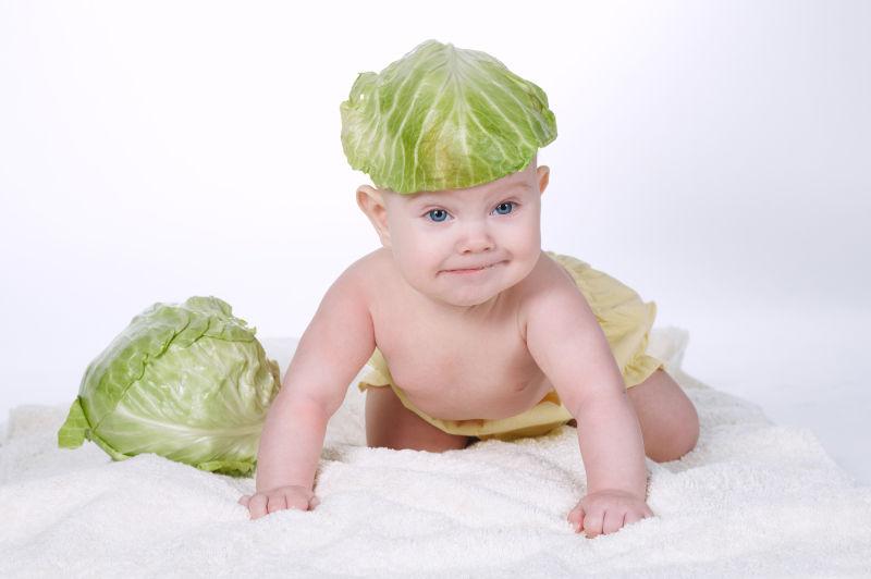 头上有卷心菜叶子的婴儿
