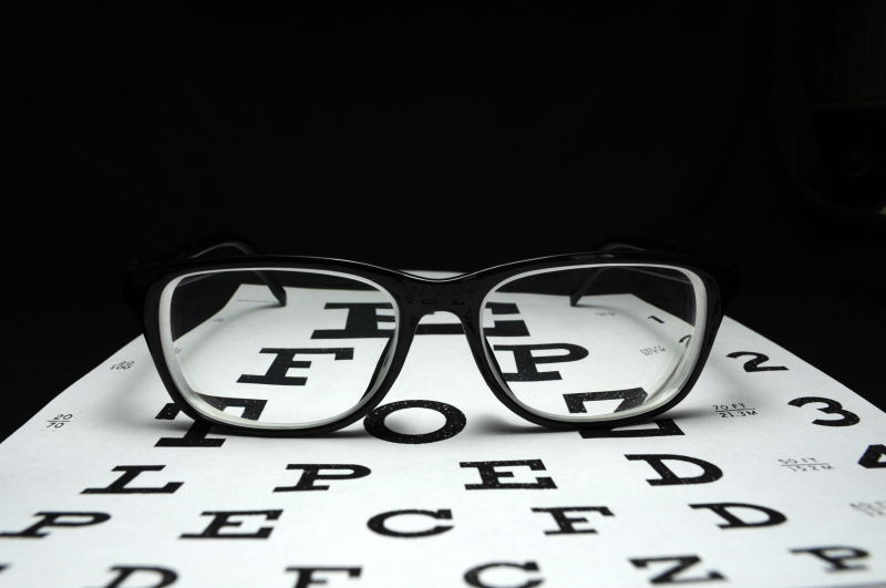黑色背景前的眼镜和英文字母