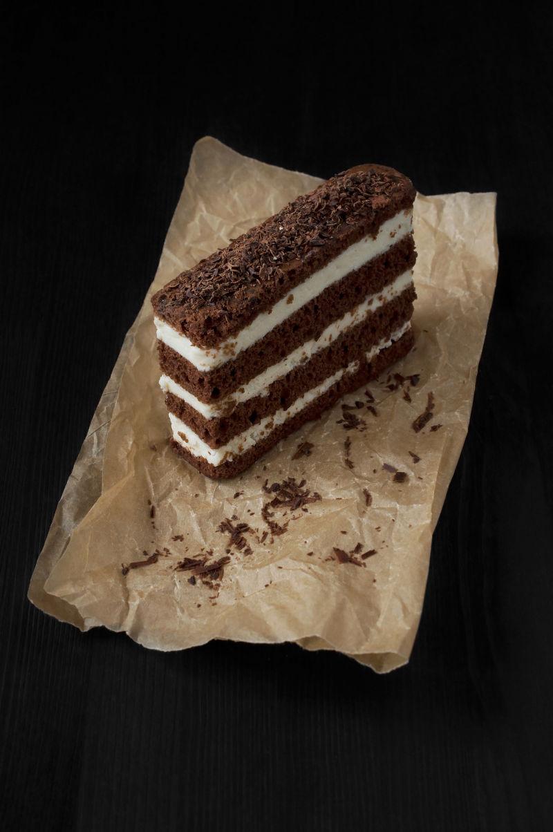 黑色背景上羊皮纸上的巧克力蛋糕