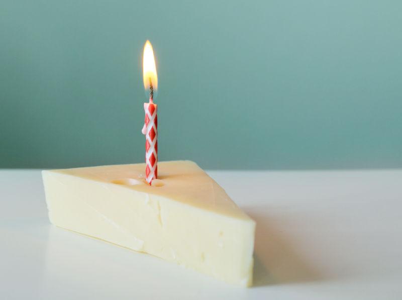 白色桌上的芝士蛋糕上的蜡烛