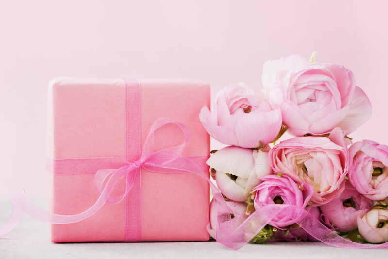 粉色背景上的礼物与粉色花