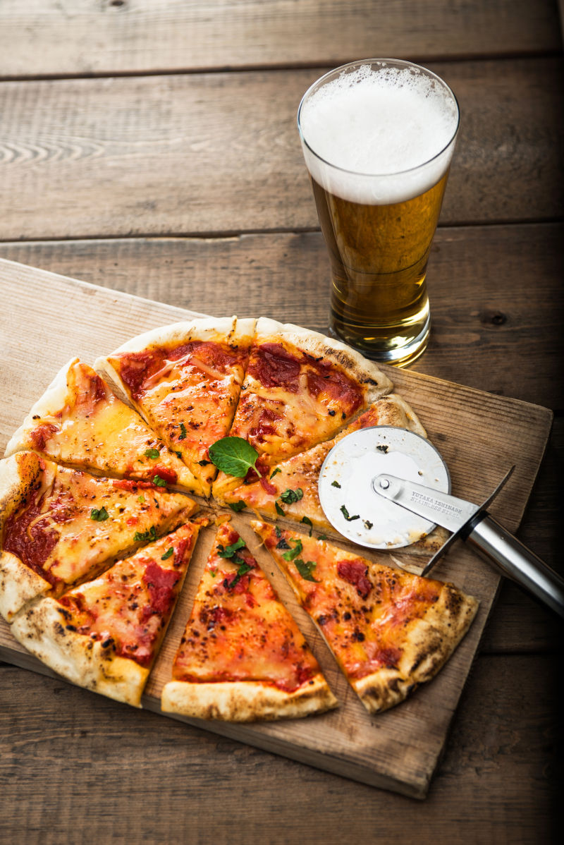 木桌上的披萨饼和啤酒