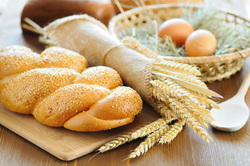 木桌上的小麦面包与麦穗