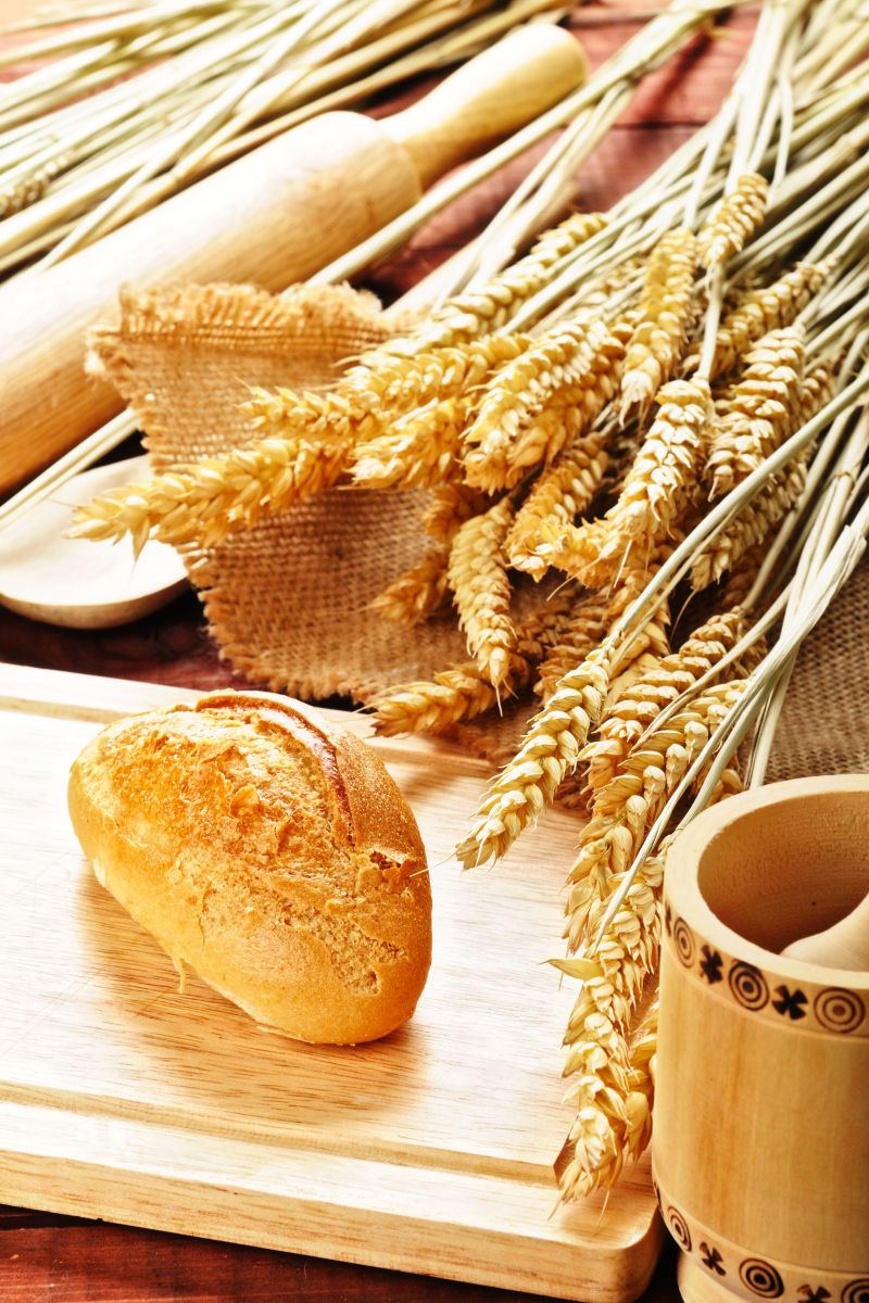 木桌上的传统面包与小麦