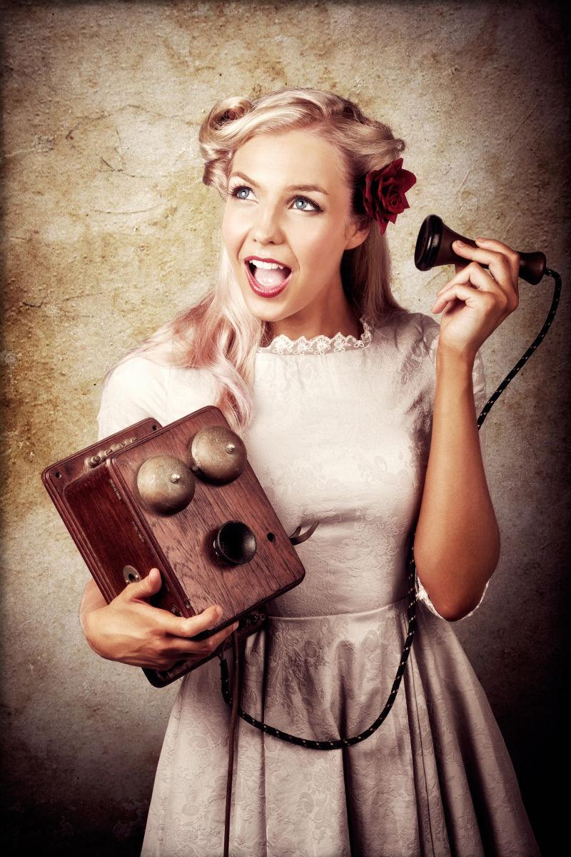 年轻女士拿着旧木箱电话