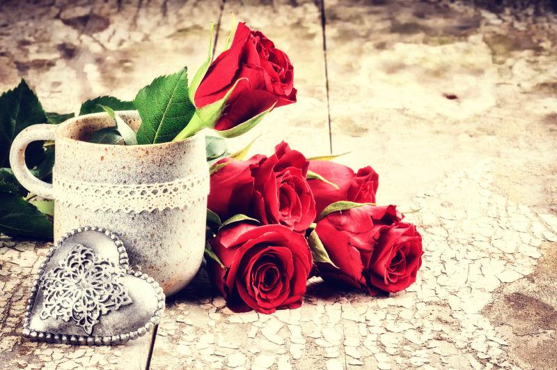 木版上情人节的红玫瑰花束和心形装饰品