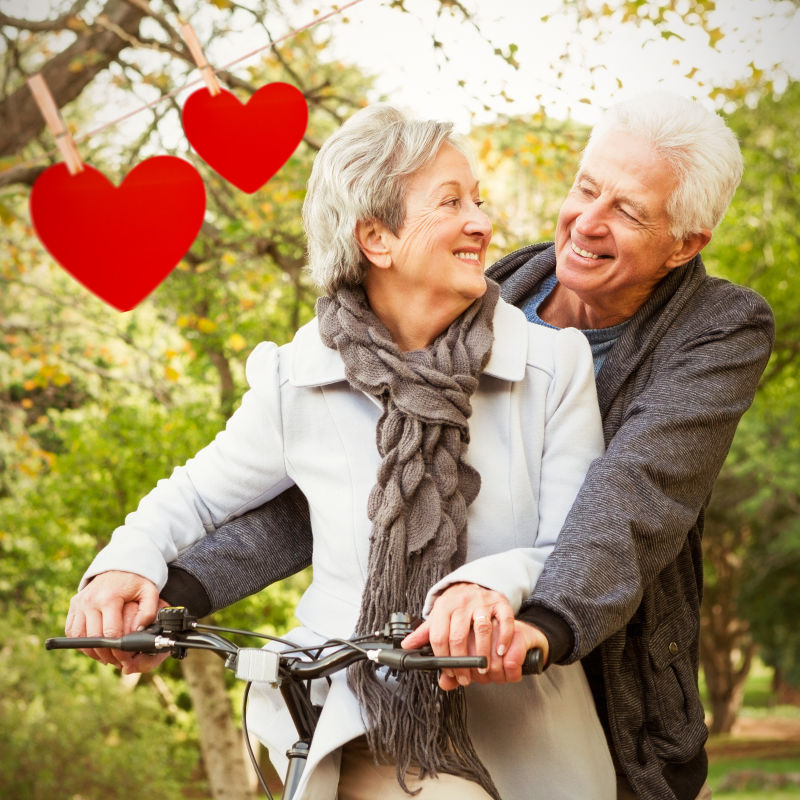 情人节老年情侣一起骑自行车和红心卡片