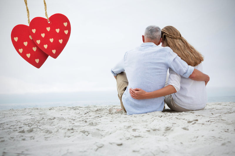 海滩情侣夫妇拥抱和挂线红色卡片