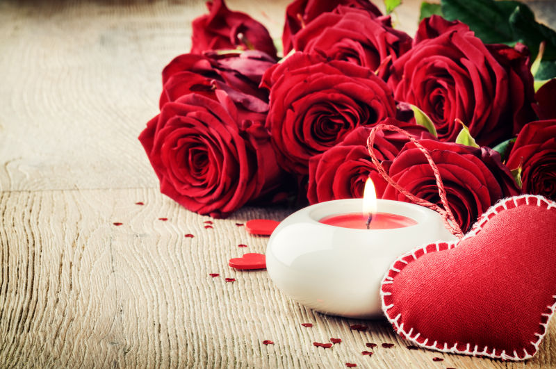 情人节的旧地板上的红玫瑰花束和蜡烛