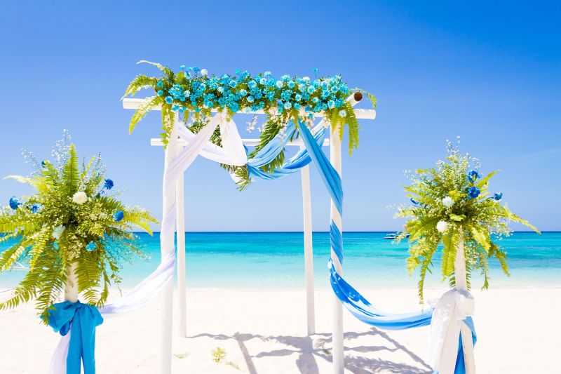 热带沙滩上鲜花装饰的婚礼拱门