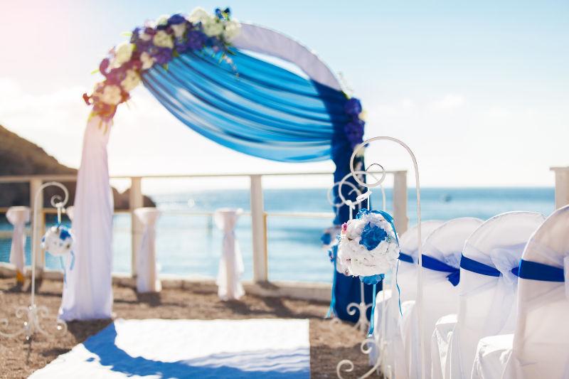 海滩上婚礼现场的蓝纱拱门
