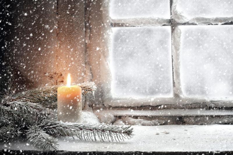 冬季圣诞节窗台上雪地里的蜡烛