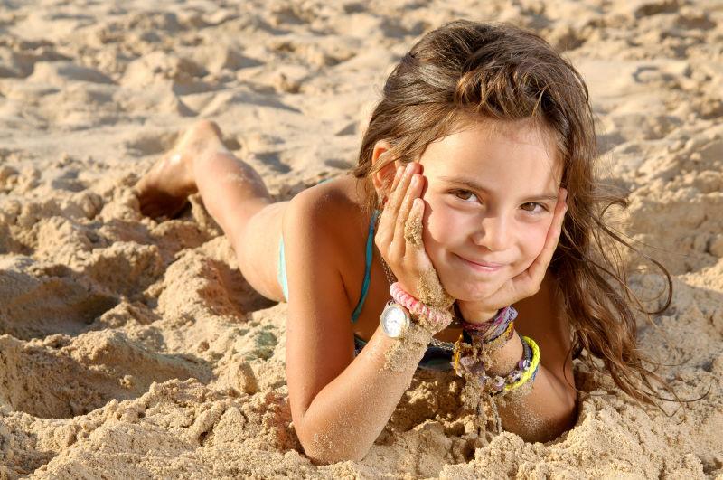 趴在沙滩上的小女孩
