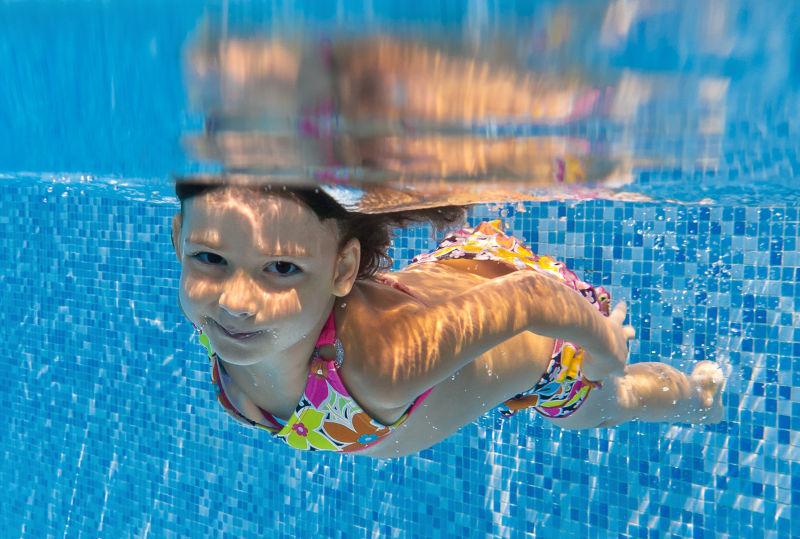 快乐的水底微笑的孩子在游泳池里