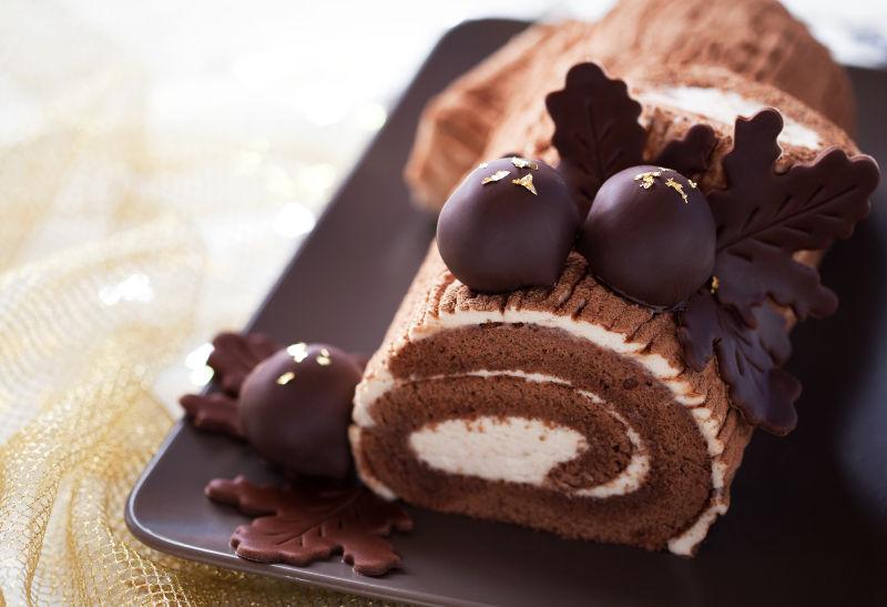 白色背景上褐色托盘里的传统巧克力圣诞蛋糕