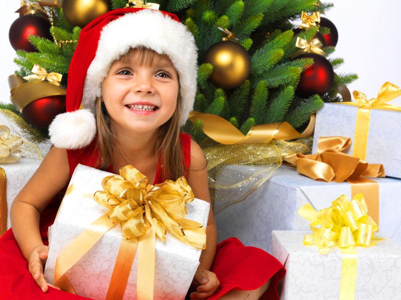 美丽的女孩在圣诞树旁微笑着
