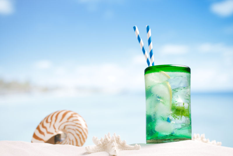 海滩上的绿色鸡尾酒和贝壳