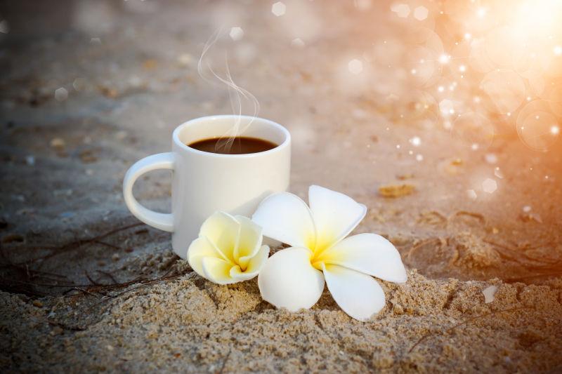 沙滩上的一杯咖啡和花朵