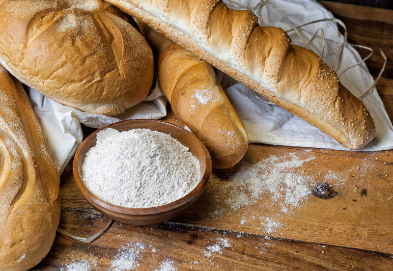 木桌上的面包与小麦粉