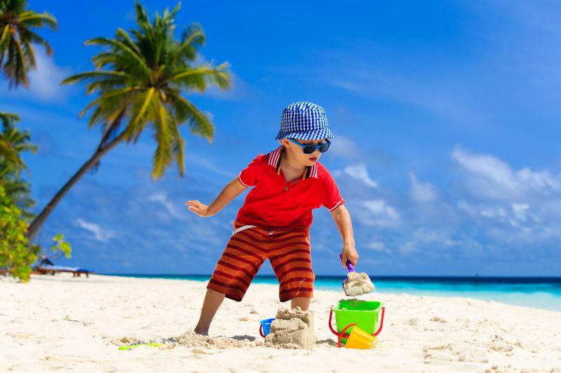 可爱的小男孩在玩沙子